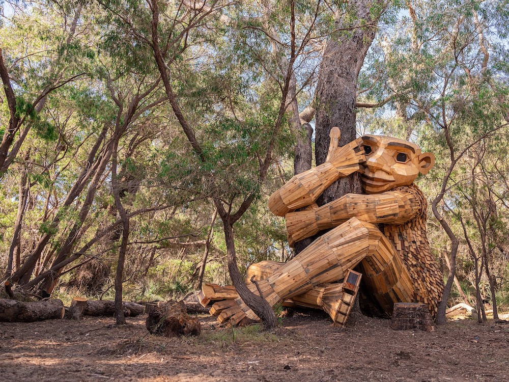 Wood troll hugging a tree.